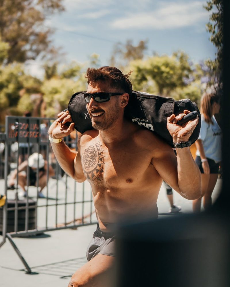 Mario Sassi cargando un sandbag sobre los hombros